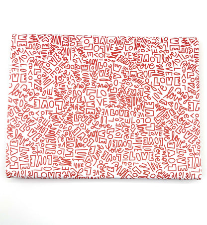 Wrapping paper with a repeating red pattern of the word "LOVE" in various fonts and sizes.