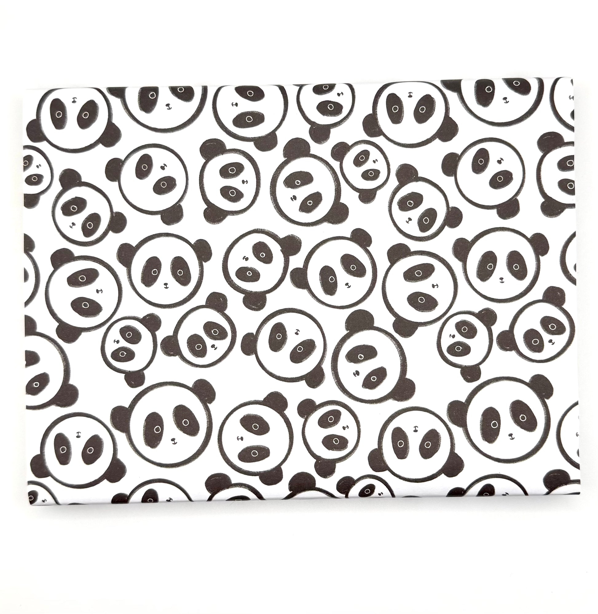 Wrapping paper with a repeating pattern of black-and-white panda faces faces.