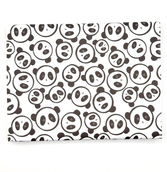 Wrapping paper with a repeating pattern of black-and-white panda faces faces.